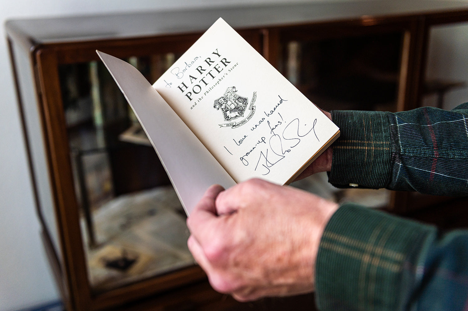 Jan Maliepaaard holding a signed copy f Harry Potter and the Pilosopher's Stone
